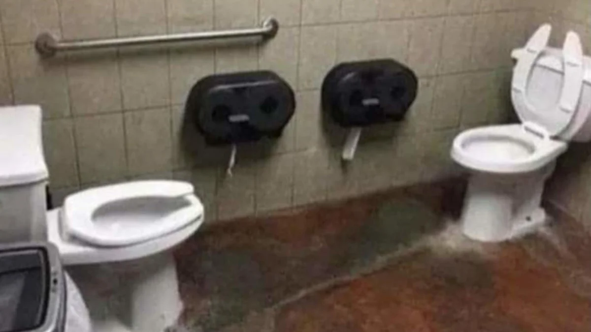 Versus Pooping — Public bathroom with two toilets facing each other without any dividing stall