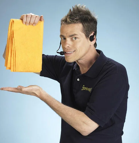 Vince Shlomi Shamwow Slap Chop — Vince Offer in headset and ShamWow polo holding orange ShamWow towels