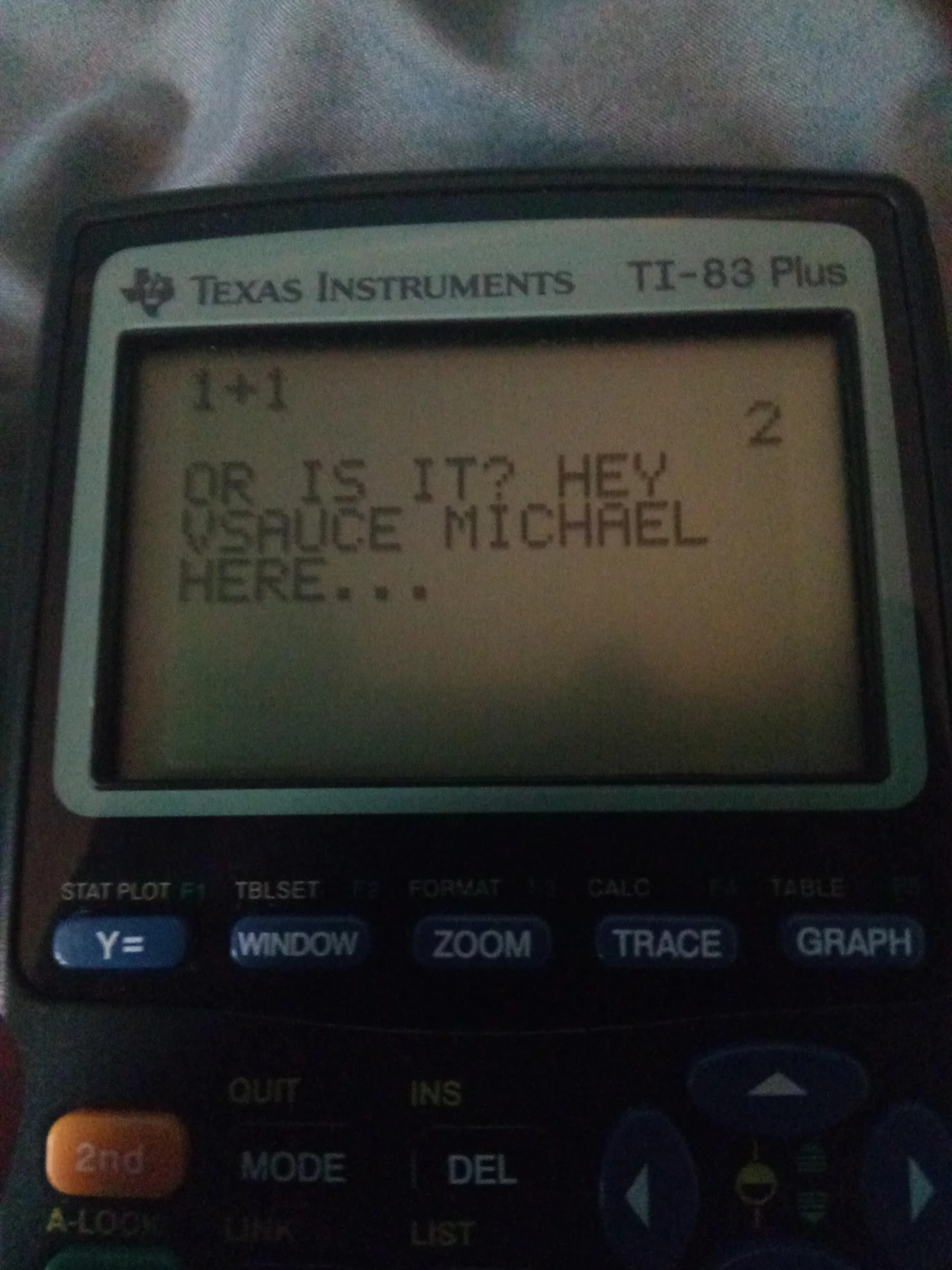 TI-83 Plus calculator screen displaying a Vsauce Michael catchphrase joke after 1 plus 1