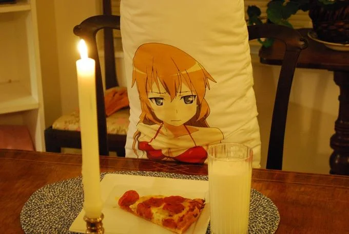 Waifu — Person holding anime poster with candles and pizza.