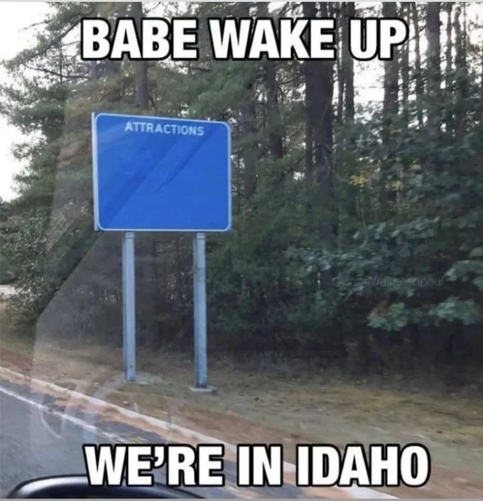 Wake Up Babe — Blue 'Attractions' road sign captioned 'BABE WAKE UP WE'RE IN IDAHO'