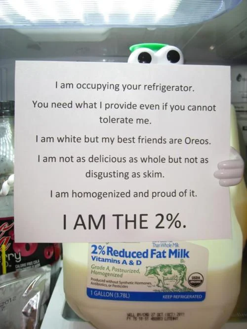 We Are The 99 Percent — Milk carton cartoon character holds a parody sign declaring 'I AM THE 2%'.