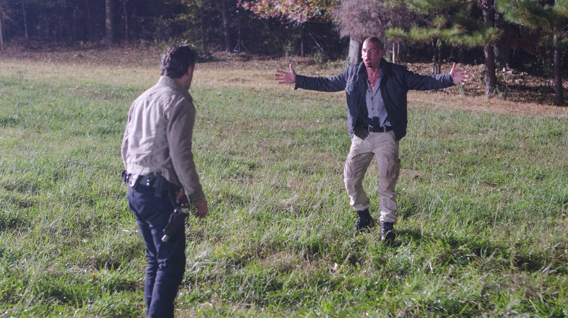 What Happened Rick I Thought You Werent The Good Guy Anymore — Rick Grimes confronting a man with outstretched arms in a grassy field from The Walking Dead
