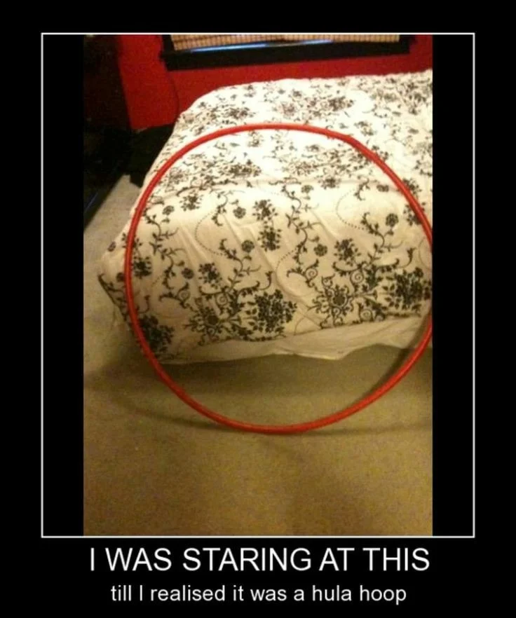 When You See it... — Bed with floral comforter and red hula hoop appearing as an optical illusion