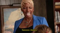 Yaass — Older person with blonde hair in blue outfit with 'YAAASS HUNTY' text overlay.