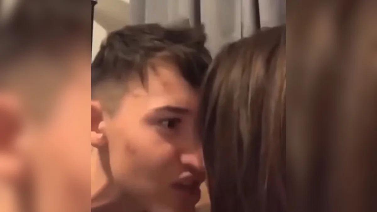 You, Me, Gas Station — Close-up of a young man leaning in and whispering into a woman's ear