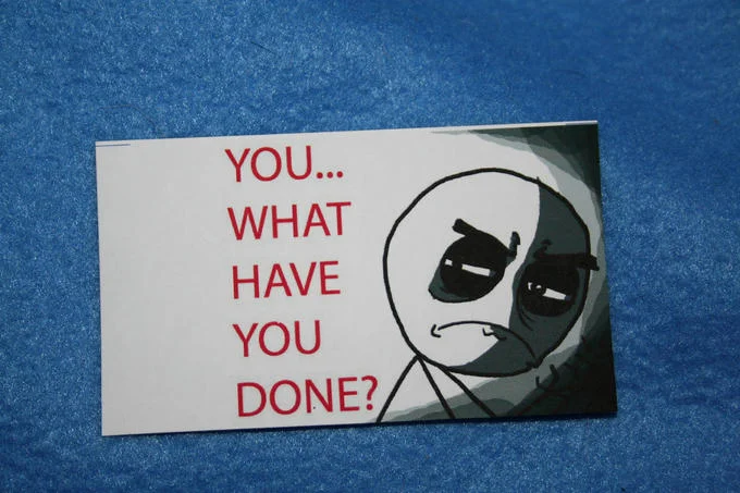 You...What Have You Done? — Printed sticker of the 'You... What Have You Done?' meme on a blue surface.
