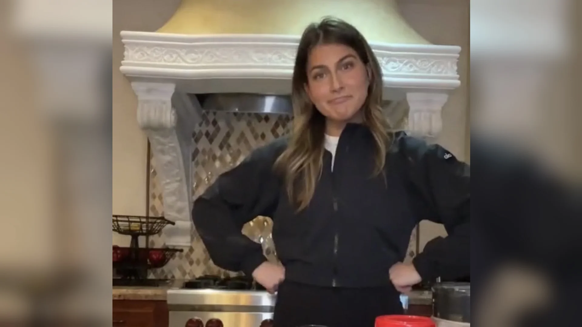 Zoe Barrie's Cooking Advice — Zoe Barrie standing hands on hips in a kitchen in front of an ornate white range hood